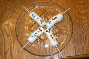Chocolate Dipped Goodies Marshmallows on a sucker stick, dipped in white chocolate with mini m&m's and gf pretzels for arms