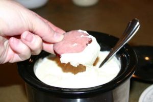 Dipping sausage into the cheese fondue