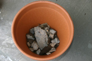 Rocks on the bottom of the pot helps with drainage- Hillside Fairy Garden